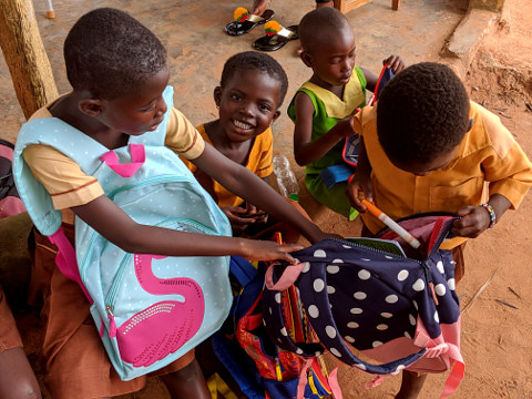 Children excited with backpacks received from the Canadians