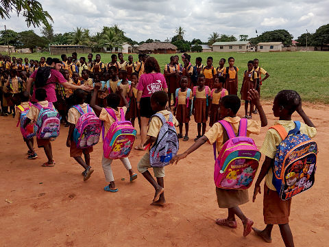 Children with new backpacks assembling in front of Dagbamate school